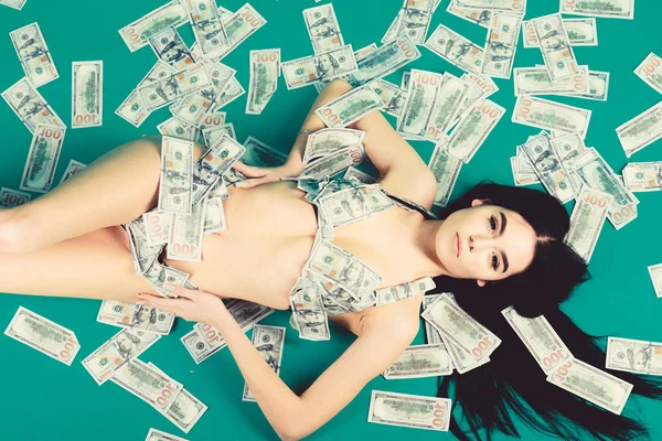 Enjoying her profit. Girl sexy breasts long hair relaxing cash money background. Richness and wellbeing. Sexy girl wear bikini dollar banknotes. Luxury girlfriend. Rich woman sexy body. Luxury resort