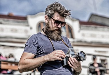 Elle ayarlar. Fotoğrafçı klasik fotoğraf makinesini tutar. Modern blogcu. İçerik yaratan. Sakallı hippi fotoğrafçı. Sakallı ve bıyıklı bir fotoğrafçı. Adam fotoğraf çekiyor. Yaşlı ama hala iyi.