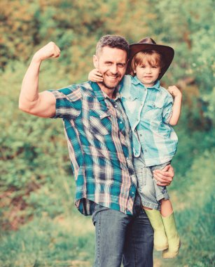 Çocuk eğleniyor kovboy baba. Rustik bir aile. Büyüyen sevimli kovboy. Bahçede küçük bir yardımcı. Küçük çocuk ve baba doğa arka plan. Macera ruhu. Babam gibi güçlü. Güç baba olmak