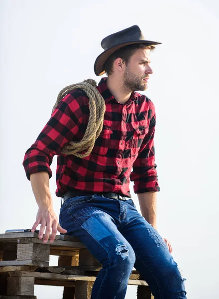 Por allí. Hombre de estilo vintage. Vaquero retro del Salvaje Oeste. vaquero con cuerda de lazo. Western. retrato vaquero occidental. rodeo del oeste salvaje. Un hombre reflexivo con sombrero, relájese. hombre camisa a cuadros en rancho —  Fotos de Stock