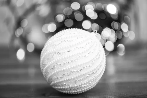 青い木製の表面にボール飾り。クリスマス ツリーのためのカラフルな装飾を選択します。多重ガーランド カラフルなライトの背景にクリスマス飾りの 1 つのボール。クリスマスの装飾の概念 — ストック写真