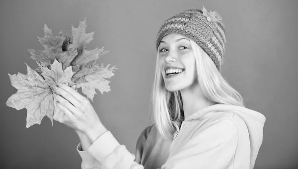 Enjoy autumn season. Autumn skincare tips. Bright moment. Skincare and beauty tips. Active leisure and rest autumn season. Woman wear knitted hat hold fallen leaves. Skincare routine for autumn