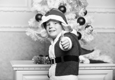 Çocuklar için Noel ağacı fikirleri. Noel ağacıyakınında sevimli elf büyülü yaratık beyaz yapay kulaklar ve kırmızı şapka gibi giyinmiş çocuk. Çocuk için Noel elf kostümü. Elf kostümü ile Noel partisi