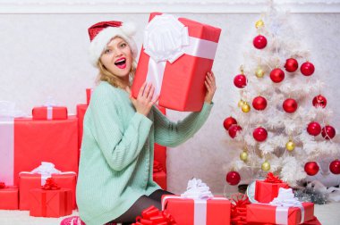 Her zaman istediği hediyeyi ver. Kadın heyecanlı sarışın yay ile hediye kutusu tutun. Noel hediyelerini açıyor. Noel ağacı nın yanındaki kız mutlu tatili kutluyor. Kız arkadaş veya eş için mükemmel bir hediye