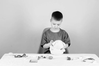 Tıp eğitimi. Çocuk sevimli çocuk gelecek Doktor kariyer. Sağlık. Çocuk küçük doktor meşgul masada tıbbi aletler ile oturup. Tıp konsepti. Teddy Bear için tıbbi prosedürler. Tıbbi muayene