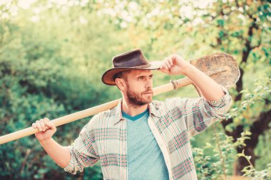 mutlu dünya günü. Eko yaşam. seksi çiftçi kürek tutun. Eko çiftlik. Hasat. tarım ve tarım saldirisi. Bahçe ekipmanları. kovboy şapkalı kaslı çiftlik adamı. Çiçeklerin iyi bakıma ihtiyacı var.