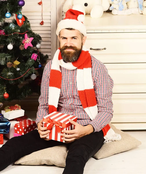 Man with beard holds present box. Santa Claus in hat — Stock Photo, Image