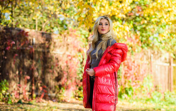 Girl wear red bright warm jacket. Fall fashion concept. Lady attractive fashionista posing in jacket. Jacket for fall season concept. Woman fashionable blonde with makeup stand in autumnal park