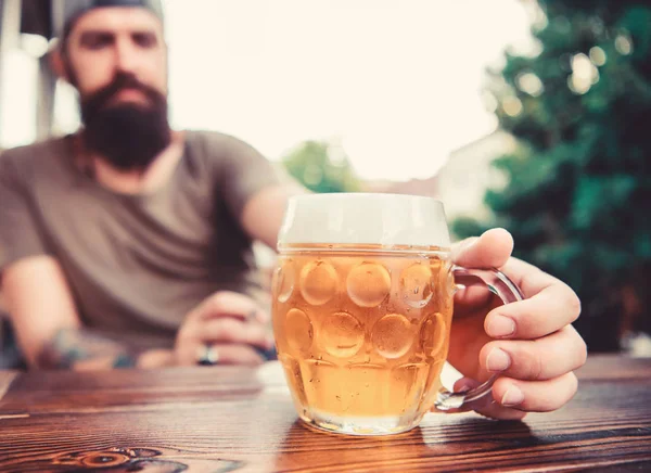 Alkol ve bar kavramı. Yaratıcı genç biracı. El yapımı bira genç, kentsel ve modaya uygun. Farklı bira kültürü. Masanın üzerinde soğuk taze bira var. Adam kafeteryada oturmuş biranın tadını çıkarıyor. — Stok fotoğraf