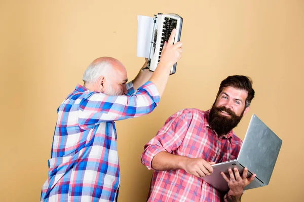 Battle time. retro typewriter vs laptop. New technology. technology battle. Modern life. father and son. family generation. youth vs old age. business approach. two bearded men. Vintage typewriter — Stock Photo, Image