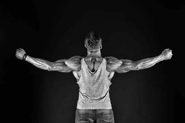 Dare to be great. Fit man back view. Fit athlete showing muscular power on black background. Strong sportsman with fit built and biceps triceps. Being fit and healthy, vintage filter