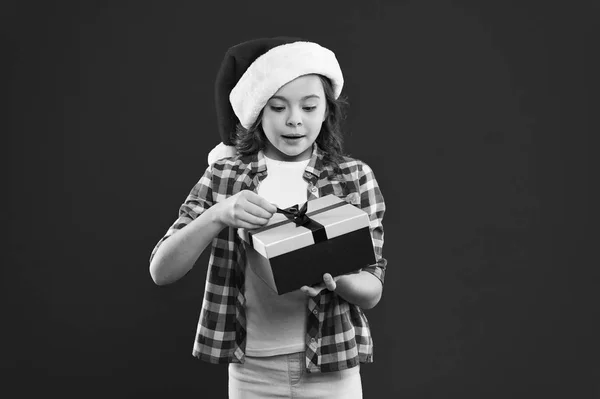 Boas férias de inverno. Menina pequena. Festa de Ano Novo. Miúdo do Pai Natal. Compras de Natal. Presente para o Natal. Infância. Criança no chapéu vermelho do Pai Natal. Tão satisfeito. — Fotografia de Stock