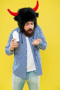 Adam ya vitamin ya da ilaç şişesini tutar. Boynuzlu adam gücü ve gücü simgeliyor. Protein konusunda saçmalamayı kes. Kas yapmak için vücuduna gereken tüm proteini kolayca sağlarsın. Protein takviyesi