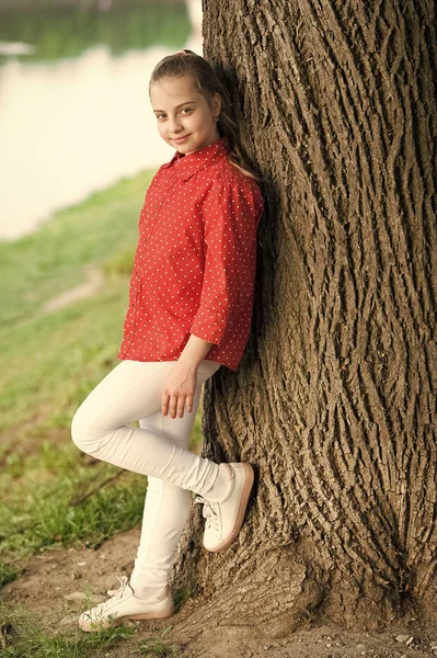 Vacker grabb. Liten söt unge med skönhetslook på naturlandskapet. Bedårande unge med långt blont hår i avslappnad stil. Liten unge klädd i mode sommaroutfit — Stockfoto