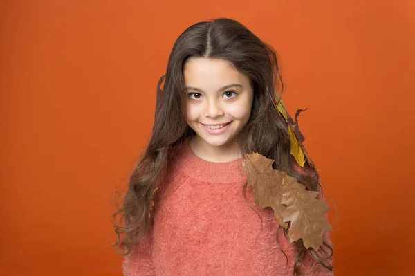 Leave haircare to professionals. Happy child wear autumn leaves in long hair. Autumn haircare. Haircare routine for fall. Seasonal changes. Haircare to avoid dry and frizzy hair. Beauty hair salon