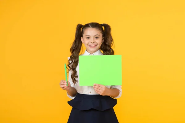 Bir kalem al. Küçük kız sarı arka plan üzerinde görev yazmak için boş kağıt tutan. Küçük çocuk bilgi yazmak için yeşil poster görüntüler. Yazma için boş gösteri kartı, kopyalama alanı — Stok fotoğraf