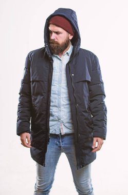Hippi kıyafet. Adam sakallı hippi beyaz izole sıcak siyah ceket parka tribünde. Hipster modern moda. Adam şapka ve siyah kış ceket giymek. Şık ve rahat. Hippi tarzı erkek giyim