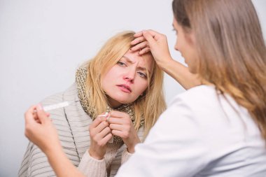 Ateşi onu rahatsız ediyor. Doktor, sağlıksız kadını evde ziyaret etti. Tıp doktoru hastayı muayene ediyor. Birinci basamak doktoru hasta kadına teşhis koyarak. Hasta bakımı ve sağlık