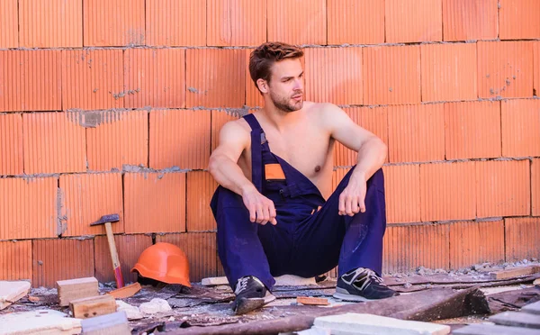 time to relax. worker brick wall background. building skills and construction. man builder in work clothes. professional repairman. turnkey project. man build house. skilled architect repair and fi