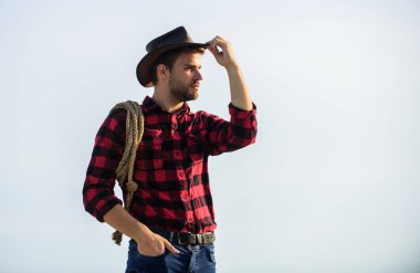 Çok uzaklara. Klasik tarz adam. Vahşi Batı eski kovboy. Çiftlikte kareli gömlek. Vahşi batı rodeosu. Şapkalı düşünceli adam rahatla. Kement ipli bir kovboy. Batı. Batı kovboy portresi