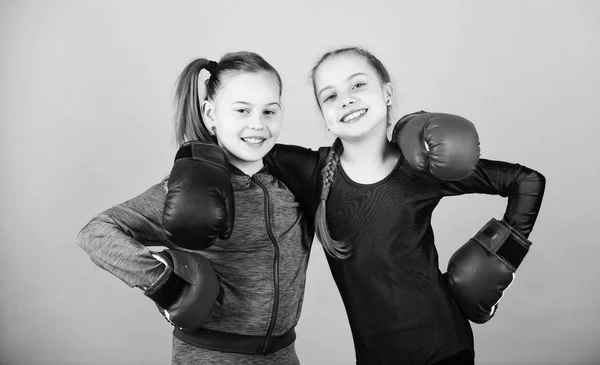 Confident teens. Female boxers. Boxing provide strict discipline. Competitors on ring and friends in life. Girls cute boxers on blue background. Girls in boxing sport. Boxer children in boxing gloves