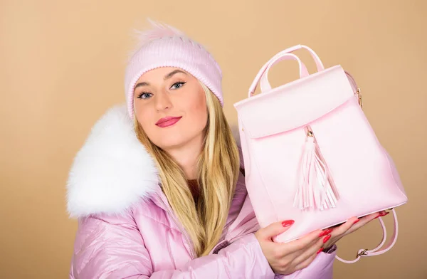 best offer. girl in puffed coat. faux fur fashion. warm winter clothing. shopping. happy winter holidays. flu and cold season. Leather bag fashion. woman in beanie hat with backpack