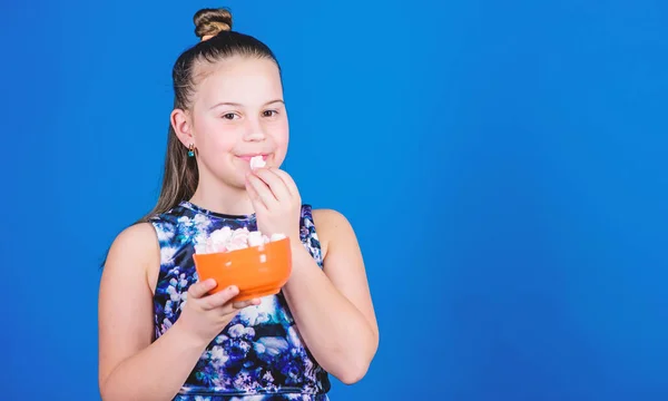 Gelukkig klein kind liefde snoep en traktaties. Klein meisje eet marshmallow. Gezonde voeding en tandheelkundige zorg. Marshmallow. Snoepwinkel. Dieet en calorie. Zoetekauw concept. Kopieer ruimte. snoepjes hebben calorie — Stockfoto
