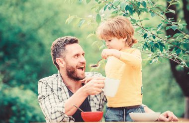 Bebeği besliyor. Çocuklar için menü. Aile ev yapımı yemeklerin tadını çıkarır. Baba oğul yemek yer ve eğlenir. Yemek alışkanlıkları. Babası yla birlikte yiyecek doğa geçmişi yiyen küçük bir çocuk. Yaz kahvaltısı. Sağlıklı gıda kavramı