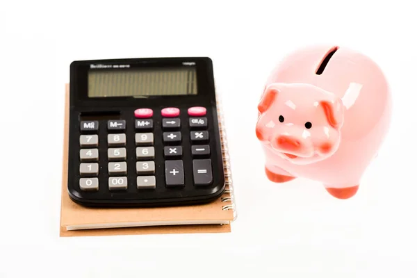 Economía y gestión de beneficios. Economía y finanzas. Hucha de cerdo rosa y calculadora. Tipos de cambio. Economía y administración de empresas. Concepto deuda de crédito. Piggy banco ahorro de dinero —  Fotos de Stock