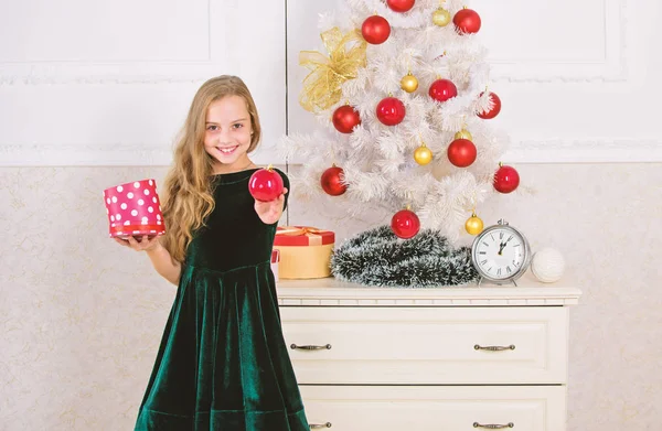 Παραδοσιακό οικογενειακές διακοπές. Παιδί κορίτσι κοντά στο χριστουγεννιάτικο δέντρο κρατήστε κουτί δώρου. Παιδί Γιορτάστε τα Χριστούγεννα στο σπίτι. Αγαπημένο ημέρα του έτους. Χρόνο για να ανοίξει τα δώρα Χριστουγέννων. Άνοιγμα των χριστουγεννιάτικων παρουσιάζει — Φωτογραφία Αρχείου