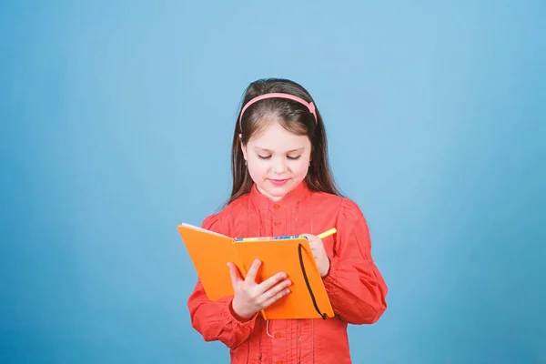 Un libro para niños. Concepto de libro. Educación para el desarrollo. Ejercicio de tarea. Escribe composición. Club de literatura. Diario personal. Estudia y aprende. Autor de poesía. Niña mantenga libro y pluma fondo azul —  Fotos de Stock