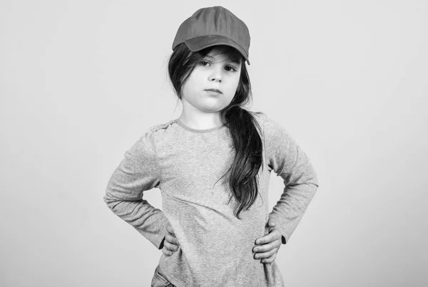 キャップのキューティー。キッズファッション。このキャップに自信を感じています。女の子かわいい子は、キャップやスナップバックハットベージュの背景を着用します。明るい野球帽をかぶった少女。モダンなファッション。スタイリッシュなアクセサリー — ストック写真