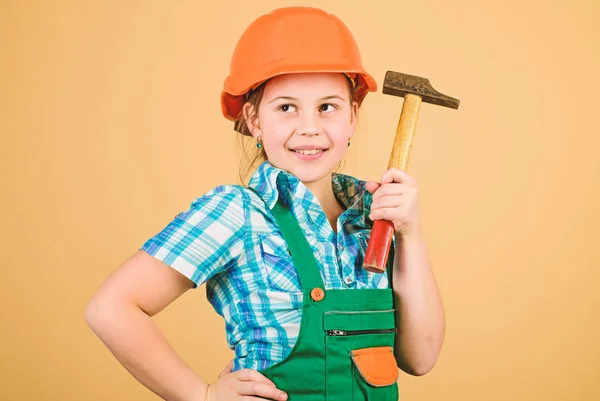 Menina pequena reparando com martelo na oficina. Profissão futura. Arquiteto engenheiro construtor. Uma criança trabalhadora de chapéu. Desenvolvimento de cuidados infantis. Ferramentas para melhorar a si mesmo. Reparação. Construa você mesmo o seu futuro — Fotografia de Stock