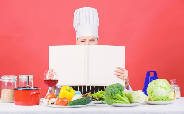 Met een uitgebalanceerd menu. Schattig vrouw leren restaurant menu voor een dag. Mooie vrouwelijke kok lezen menukaart bij keuken tafel. Menu eten en drinken lijst, kopieer ruimte — Stockfoto