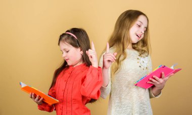 Eğitim ve çocuk edebiyatı. Favori peri masalı. Okula dönelim. Kardeşler birlikte okumak için kitap seçerler. Sevimli kızlar kitapları sever. Okuma yazma bilinci sayesinde kapıları açmak. Kitap ya da not defteri olan çocuklar.