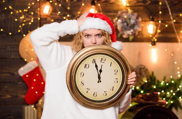 Time for winter party. Time for miracles. Few minutes left. New year countdown. Unexpectedly soon. Midnight concept. Make wish. Woman Santa hat hold vintage clock. Time to celebrate. Merry christmas