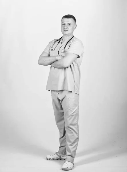 男性医師聴診医のユニフォーム。医療とヘルスケア。治療と予防。男は白い背景に医師ベージュの服を経験しました。正常性を確認します。私立診療所医師の経歴 — ストック写真