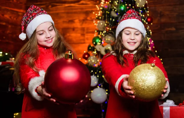 Kız kardeşler Noel Baba kostümleri. Çocuklar güzel arkadaşlar Noel tatiliyle tanışır. Aile Noel 'i kutlar. Birliktelik konsepti. Şenlikli atmosfer noel günü. Noel ağacını birlikte süsleyin. — Stok fotoğraf