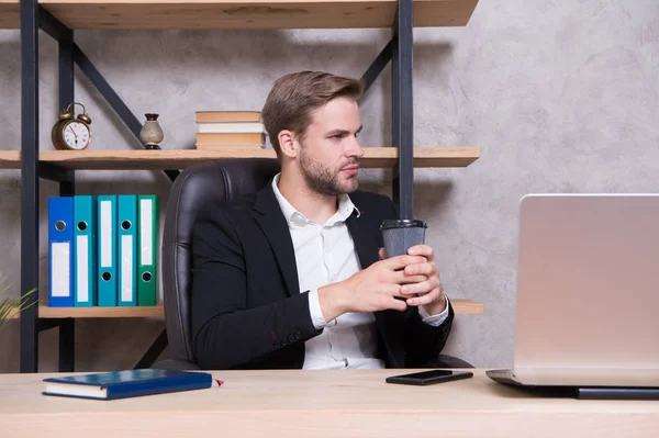 Pranzo di lavoro. Uomo d'affari che beve caffe '. L'uomo sicuro usa il computer portatile. Capo sul posto di lavoro. Un bell'uomo in ufficio. Ispirato con una tazza di caffè fresco. Concetto di amministratore delegato. Decisione commerciale — Foto Stock