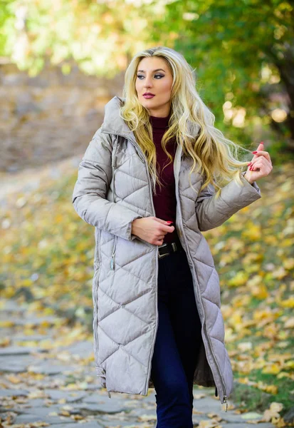 Jacket everyone should have. Oversized jacket trend. How to rock puffer jacket like star. Puffer fashion trend concept. Girl fashionable blonde walk in autumn park. Woman wear warm grey jacket