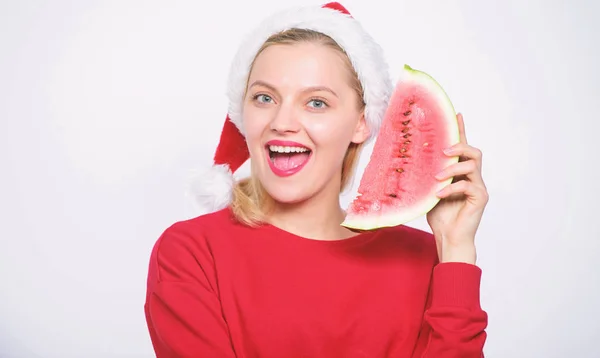 女圣诞老人的帽子拿着切片西瓜。漫长的夏天。旅游圣诞节度假度假胜地。美味的圣诞节概念。圣诞节夏季目的地。圣诞女孩吃西瓜 — 图库照片