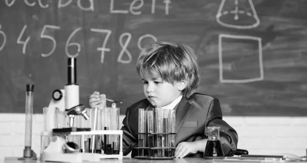 Child enjoy studying. Knowledge concept. Boy near microscope and test tubes in school classroom. Kid study biology chemistry. Knowledge day. Basic knowledge primary school education. Happy childhood
