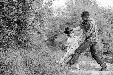Küçük çocuk çiftçilikte babasına yardım ediyor. Yeni bir hayat. Toprak ve gübre. Zengin doğal toprak. Eko çiftliği. Çiftlik. Baba ve oğul aile ağacı dikiyorlar. Dünya günün kutlu olsun. Kürekle toprağı kaz. Yeni çiçekler