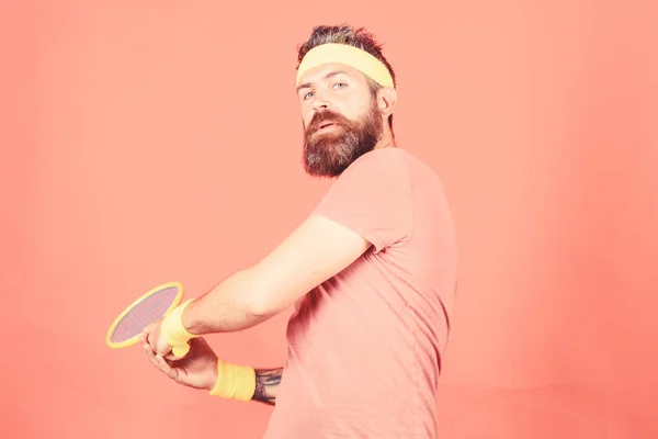 Чоловік бородатий хіпстер носить спортивне вбрання. Розважатися. Теніс активне дозвілля. Вінтажний тенісист. Тенісні види спорту та розваги. Спортсмен хіпстер тримає тенісну ракетку в руці червоний фон — стокове фото