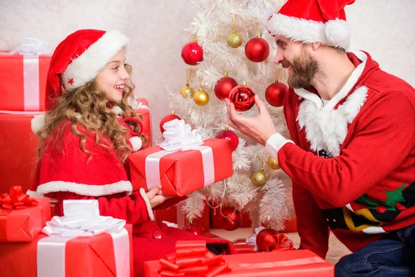Christmas family holiday. Christmas gift for child. Make your childs holiday extra special this year. Father christmas concept. Dad in santa costume give gift to daughter cute kid. Happy childhood