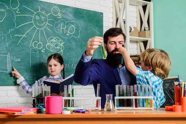 School clubs interactive education. Clubs for preschoolers. After school clubs are great way to develop kids in different areas. Chemistry experiment. Teacher and pupils test tubes in classroom