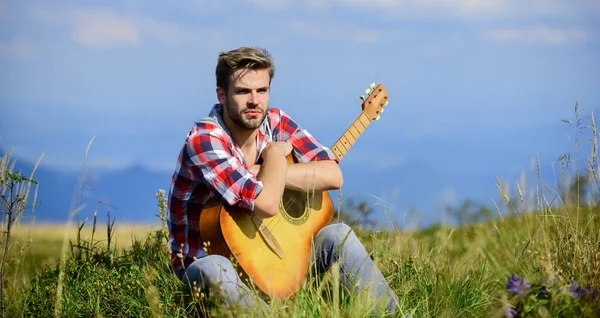 Piacevole stare da soli. Musicista in cerca di ispirazione. Un vagabondo sognante. Umore pacifico. Il tipo con la chitarra contempla la natura. Concetto di vagabondaggio. Ispirare la natura. Estate vacanze altipiani natura — Foto Stock