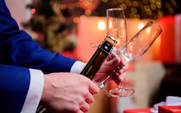 Concepto de brindis y salud. Manos masculinas abriendo botella de champán sobre fondo decoraciones navideñas. Celebremos. Abrir el champán y celebrar la fiesta. Celebrar el año nuevo con bebida de champán —  Fotos de Stock