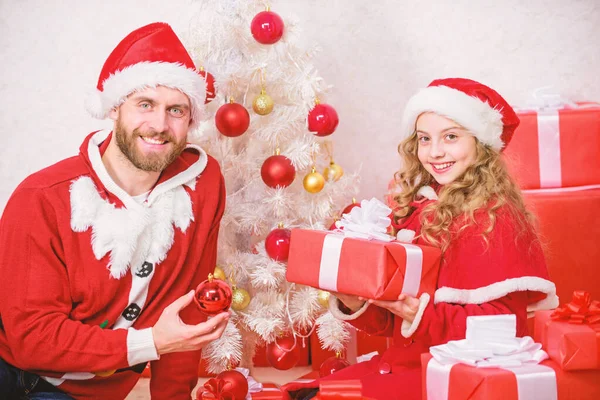 子供のためのクリスマス プレゼント。サンタ衣装でのお父さんは、娘のかわいい子供にギフトを与えます。幸せな子供時代。クリスマス家族の休日。あなたの子供は、今年の特別な休日を確認します。父のクリスマス コンセプト — ストック写真