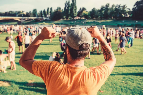 Summer fest. Man bearded hipster in front of crowd. Open air concert. Book ticket now. Early bird sale. Music festival. Entertainment concept. Visit summer festival. Guy celebrate holiday or festival